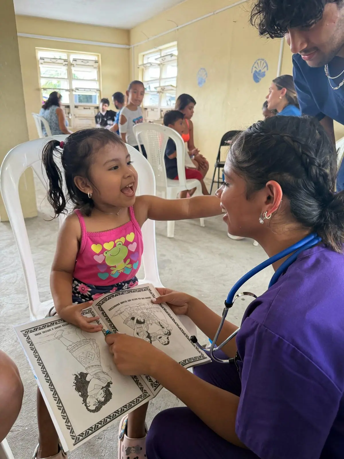 Member on a medical service trip coloring with a child