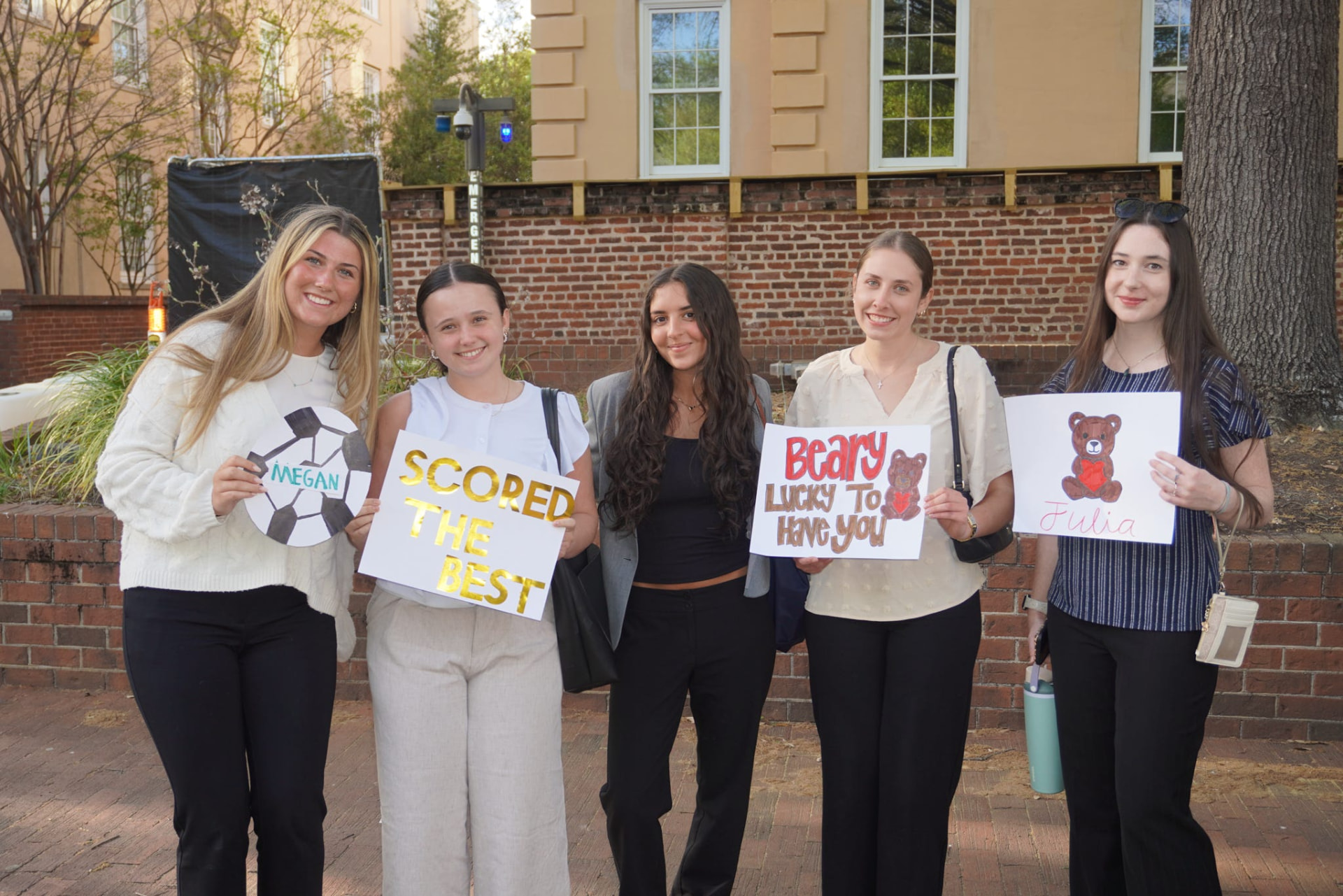Members holding handmade signs at a big-little reveal