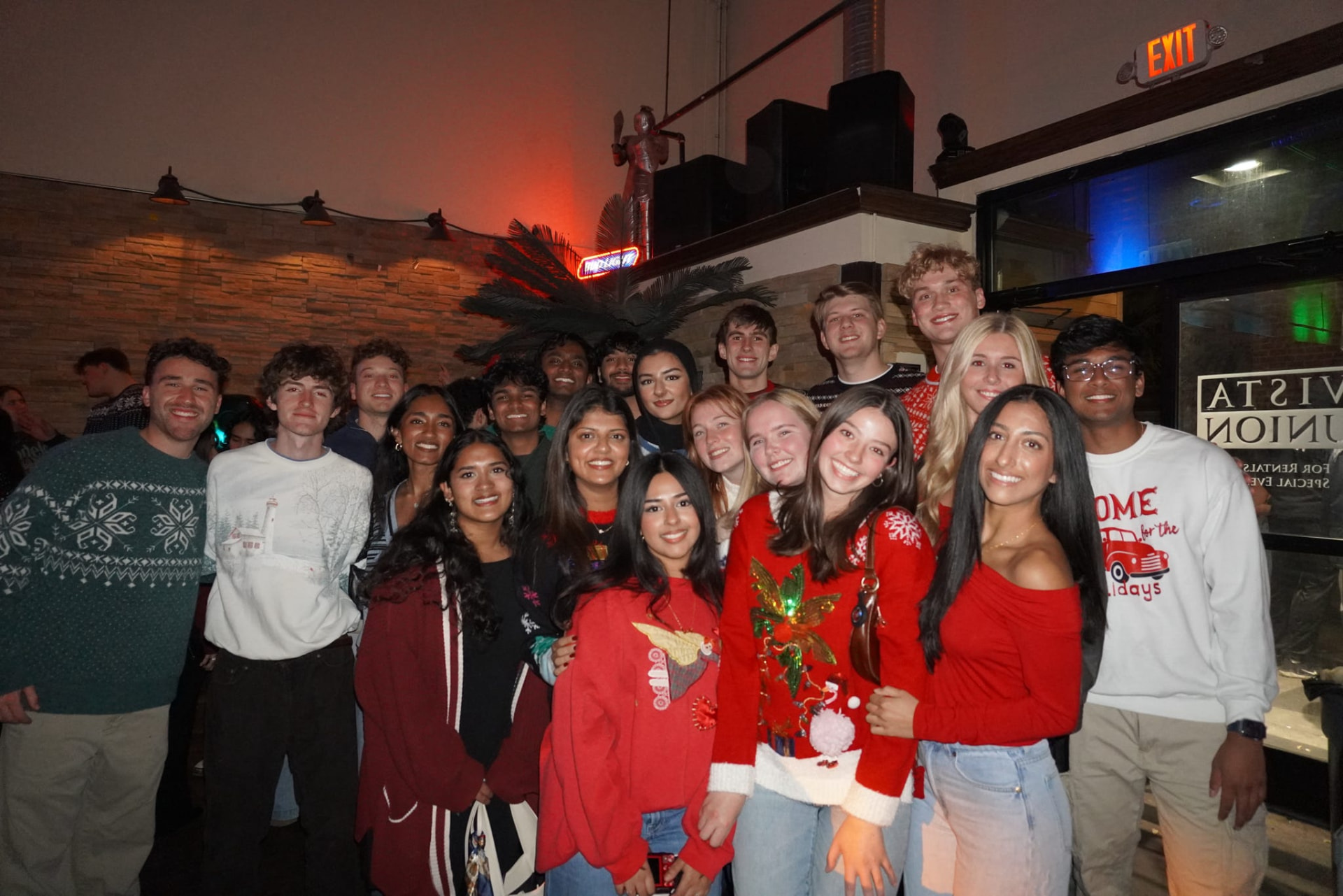Members in holiday sweaters at the AED winter social