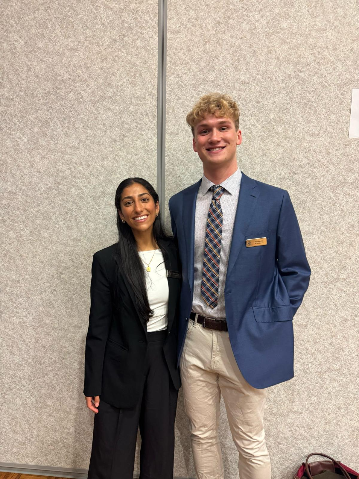 Two AED members in professional attire at a DPT/MP event