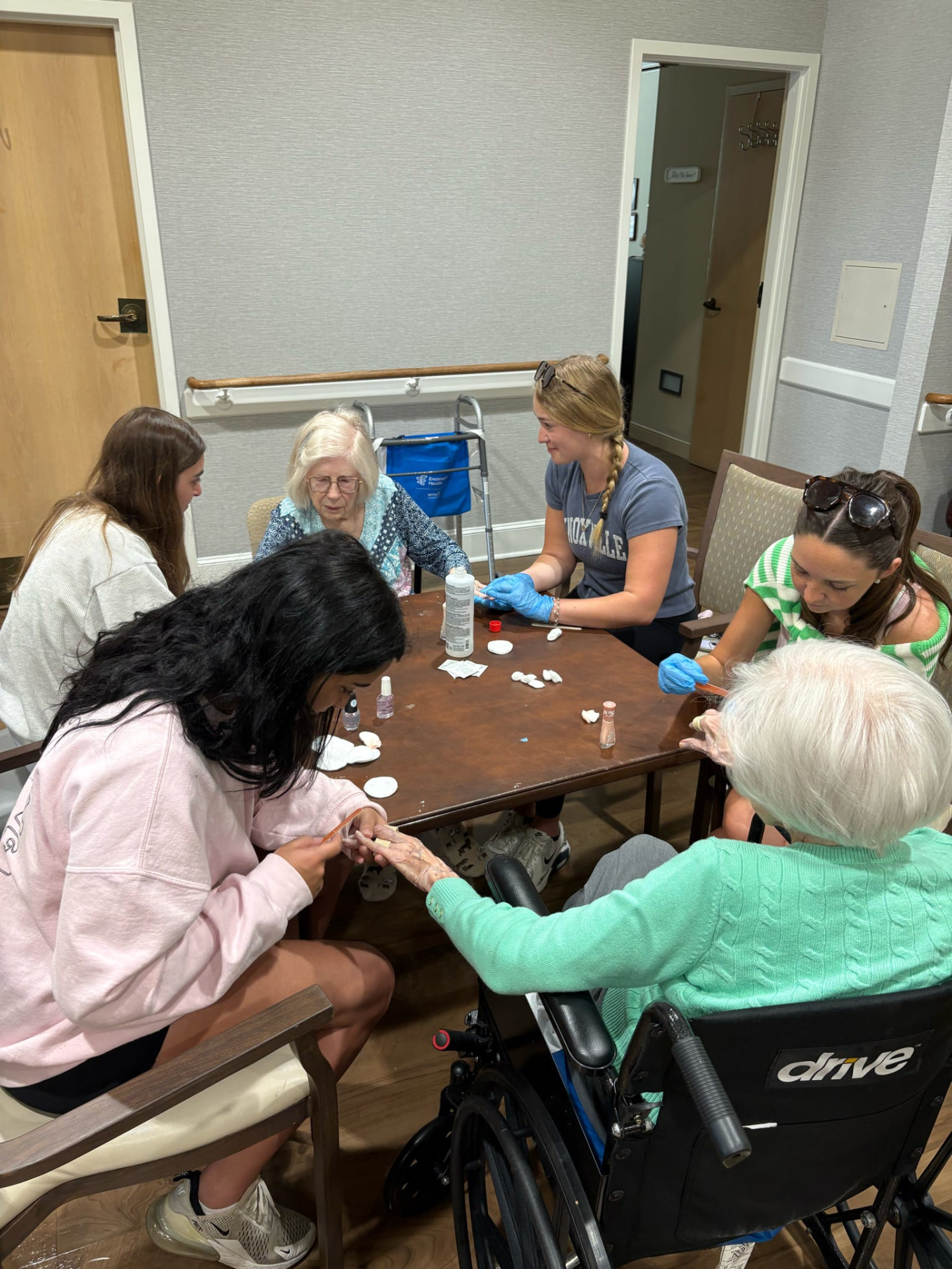 Members giving manicures to residents at a senior living community
