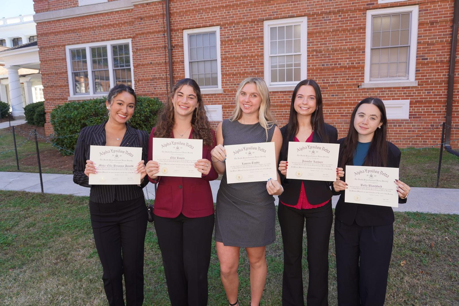 AED members holding their Alpha Epsilon Delta induction certificates