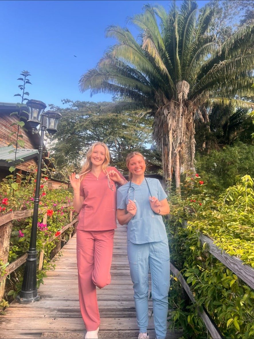 AED members in scrubs walking a garden boardwalk on a service trip