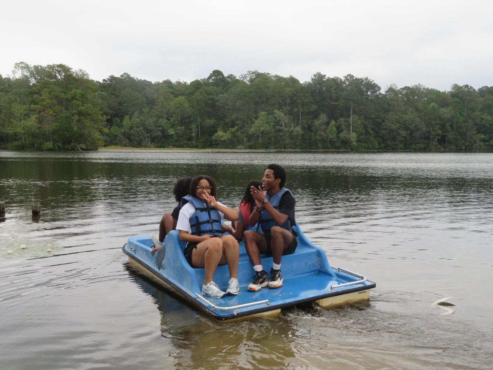 Members paddle boating on the lake at the fall retreat