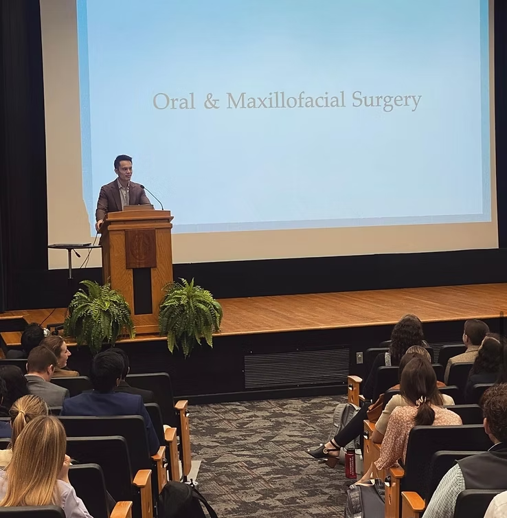 Guest speaker presenting on oral and maxillofacial surgery