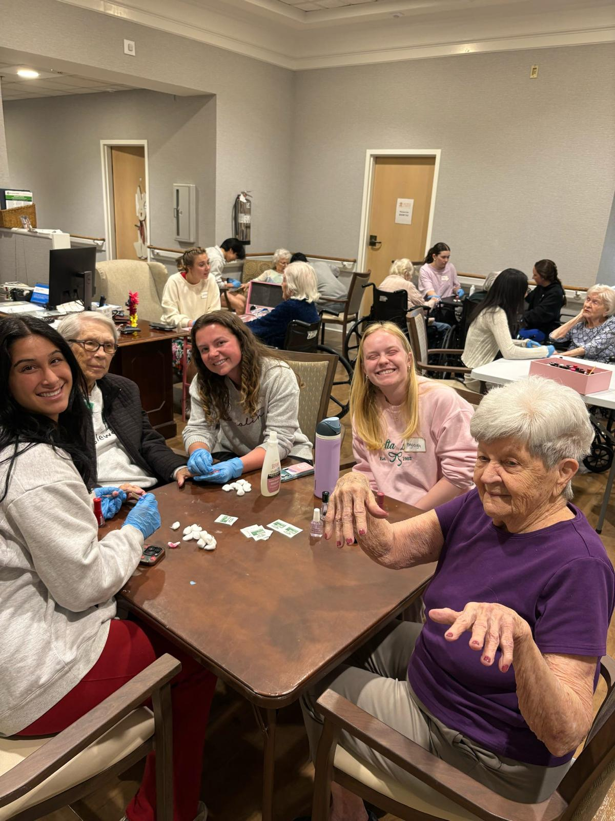 Members giving manicures to residents at a senior living center