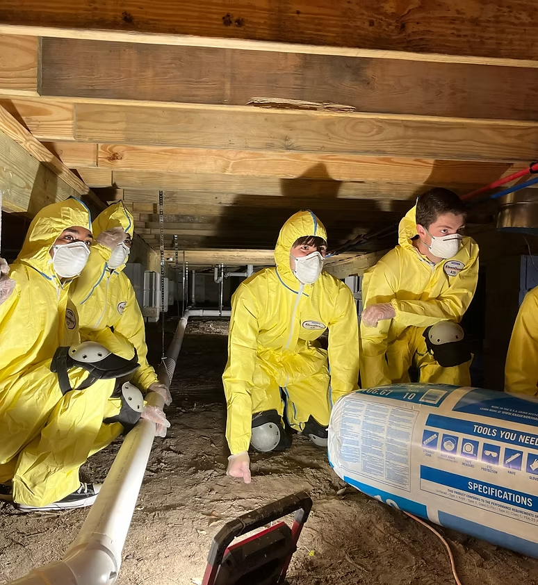 Members in protective suits volunteering on a home repair project